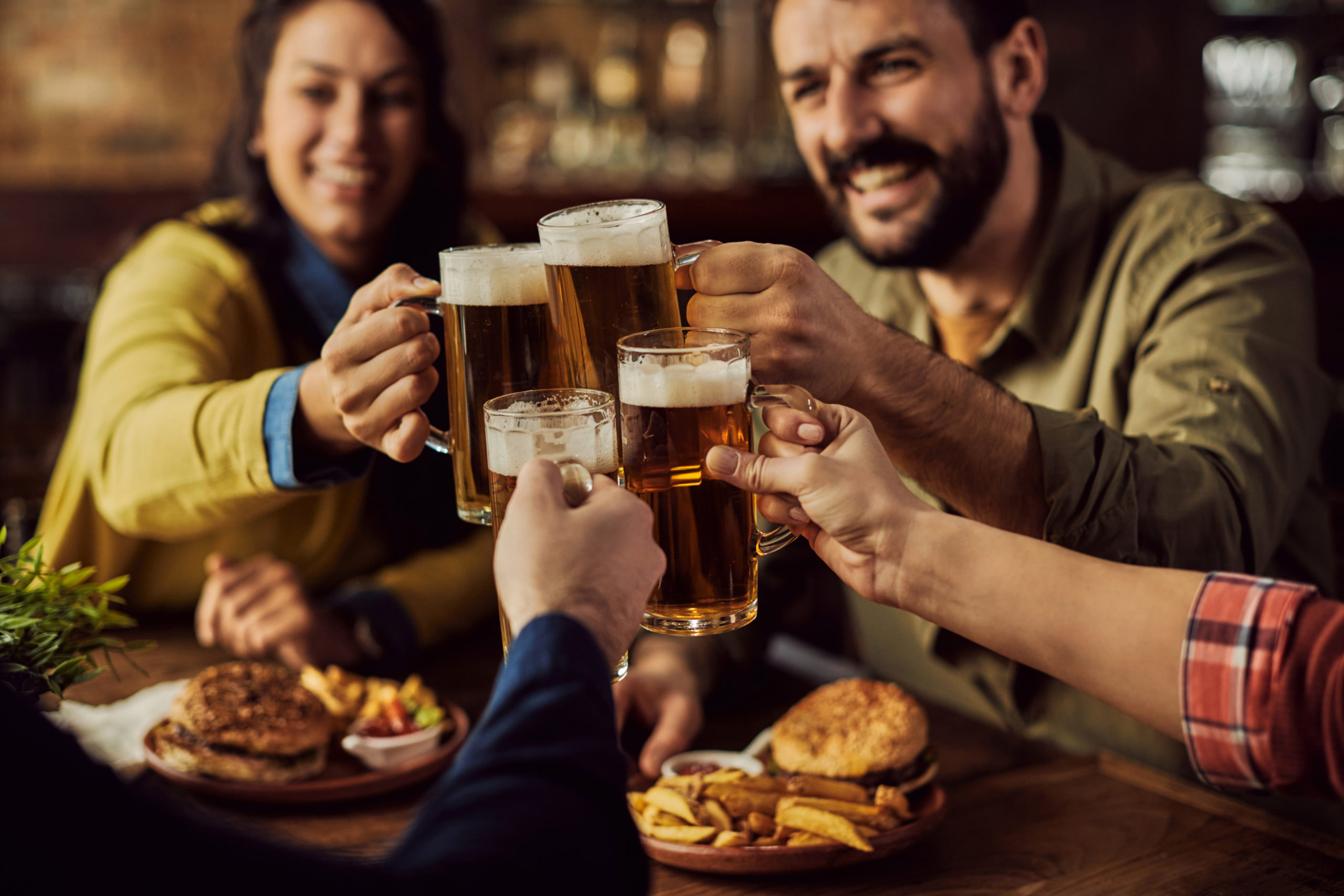 Close-up of friends toasting with beer in a pub